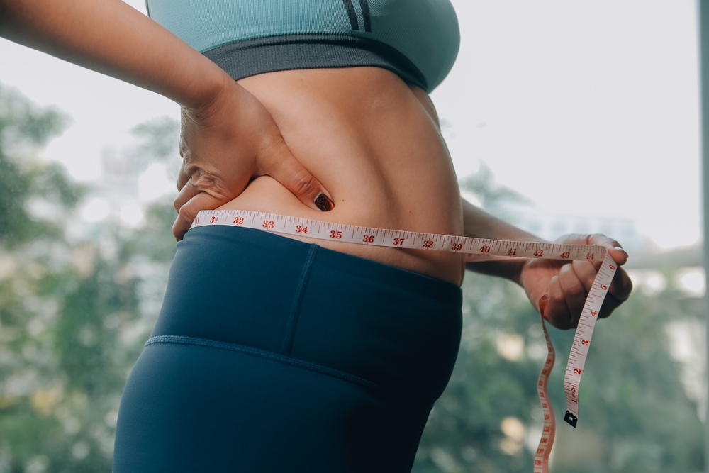 Measuring waist with a tape measure showing weight loss progress on Wegovy in Ireland